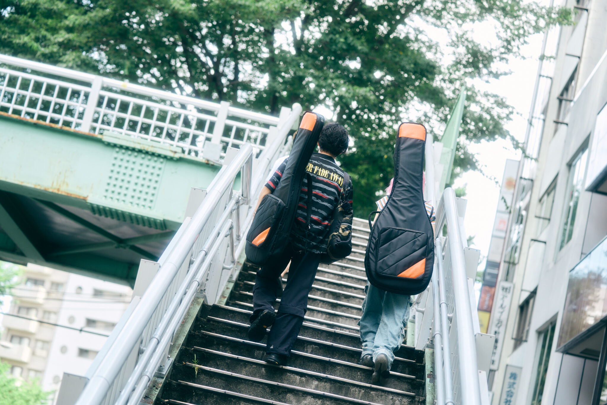ギターケースを背負って店舗へ向かう様子